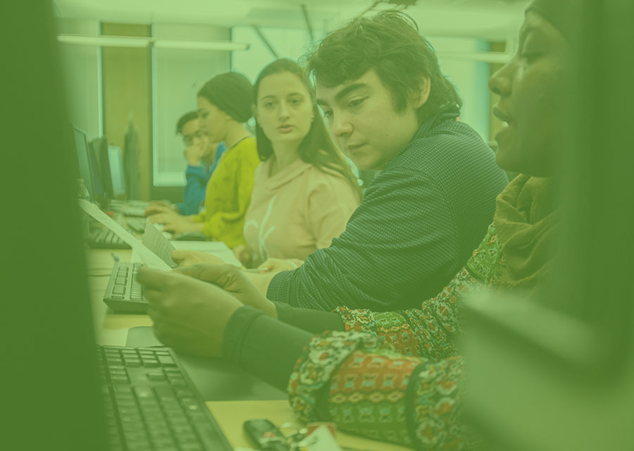 Instructor sharing instructions with students at computers.