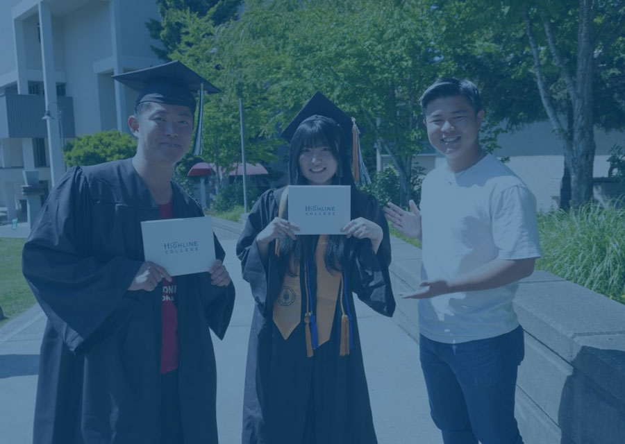 Three students at commencement with degrees