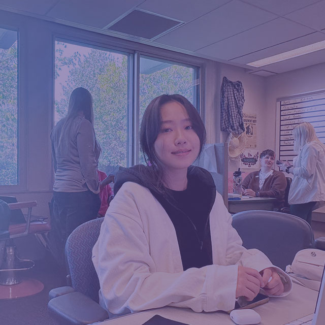 Woman working at a desk with laptop and writing