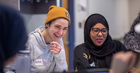 two students smile in class